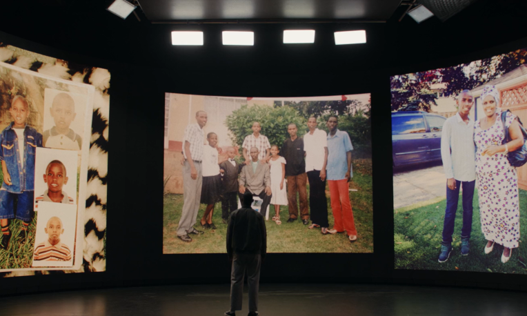 David standing in front of photos from his childhood